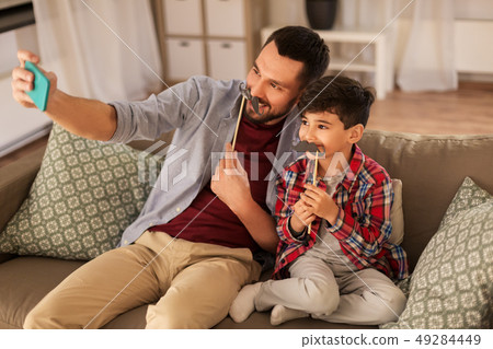 father and son taking selfie at home father and son taking selfie at home 49284449