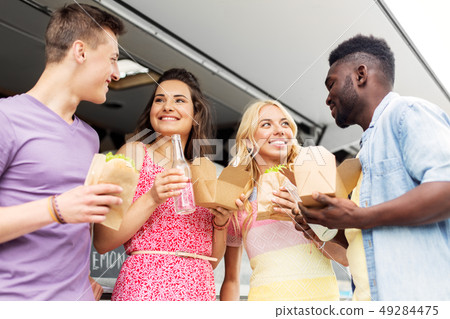 happy friends with drinks eating at food truck 49284475