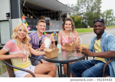 happy friends with drinks eating at food truck happy friends with drinks eating at food truck 49284488