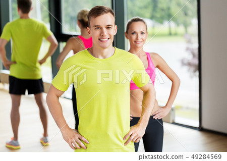 smiling man and woman exercising in gym smiling man and woman exercising in gym 49284569
