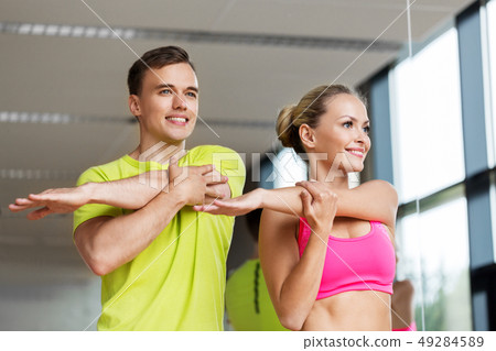 smiling man and woman exercising in gym smiling man and woman exercising in gym 49284589