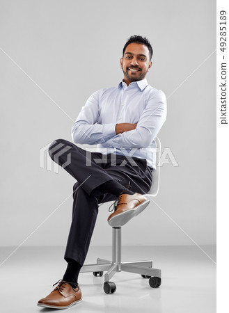 smiling indian businessman sitting on office chair 49285189