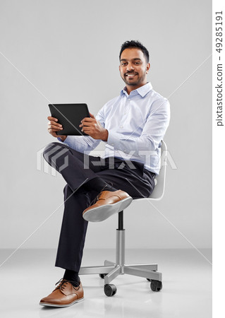 indian businessman with tablet pc on office chair indian businessman with tablet pc on office chair 49285191