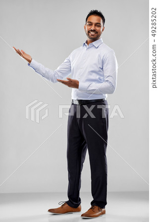 indian businessman holding something over grey 49285202