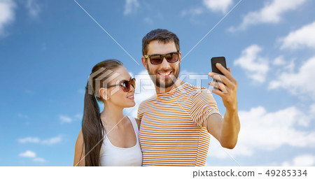 happy couple taking selfie by smartphone in summer 49285334