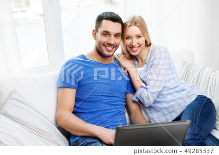happy couple with laptop computer at home happy couple with laptop computer at home 49285337