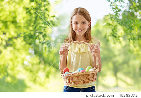 happy girl with colored eggs in wicker basket happy girl with colored eggs in wicker basket 49285372