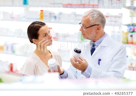 apothecary and woman with drug at pharmacy 49285377