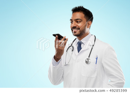 smiling indian male doctor calling on smartphone smiling indian male doctor calling on smartphone 49285399
