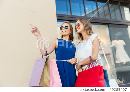 happy women with shopping bags at storefront happy women with shopping bags at storefront 49285407
