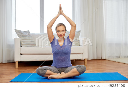 woman meditating in lotus pose at home 49285408