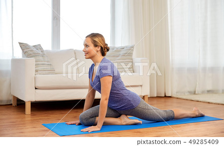woman doing swan yin yoga pose at home 49285409