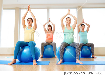 pregnant women sitting on exercise balls in gym 49285435