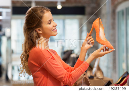 happy young woman choosing shoes at store happy young woman choosing shoes at store 49285499