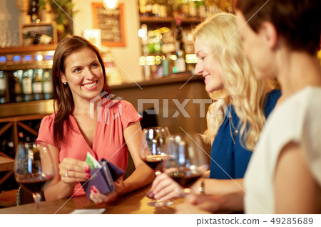 women paying bill at wine bar or restaurant 49285689