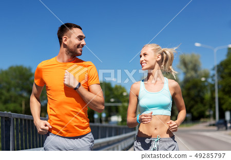 couple with fitness trackers running along bridge couple with fitness trackers running along bridge 49285797