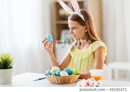 happy girl with colored easter eggs at home 49285871