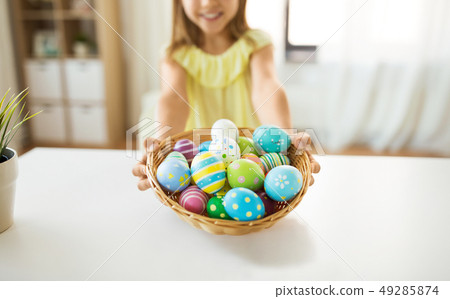 close up of girl with easter eggs in wicker basket close up of girl with easter eggs in wicker basket 49285874