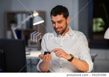 businessman using smart speaker at night office businessman using smart speaker at night office 49285996