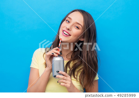 young woman or teenage girl drinking soda from can young woman or teenage girl drinking soda from can 49285999