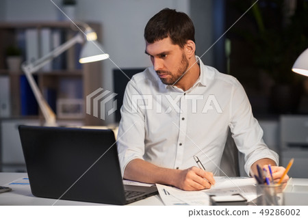 businessman with laptop working at night office businessman with laptop working at night office 49286002