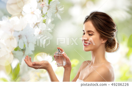 happy woman with perfume over cherry blossoms happy woman with perfume over cherry blossoms 49286226