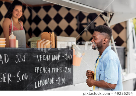 male customer looking at billboard at food truck male customer looking at billboard at food truck 49286294