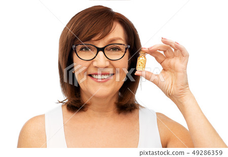 senior woman with gold facial mask in bottle senior woman with gold facial mask in bottle 49286359