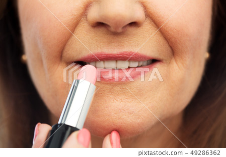 close up of senior woman applying lipstick close up of senior woman applying lipstick 49286362