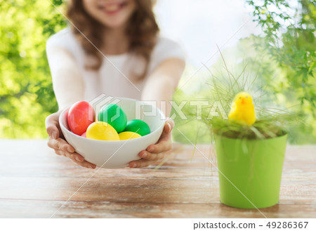 close up of girl with bowl of colored easter eggs close up of girl with bowl of colored easter eggs 49286367