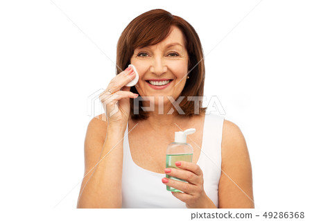senior woman cleaning face by lotion on cotton pad senior woman cleaning face by lotion on cotton pad 49286368
