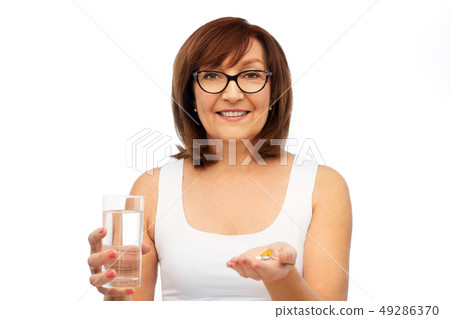 senior woman with glass of water and pills senior woman with glass of water and pills 49286370