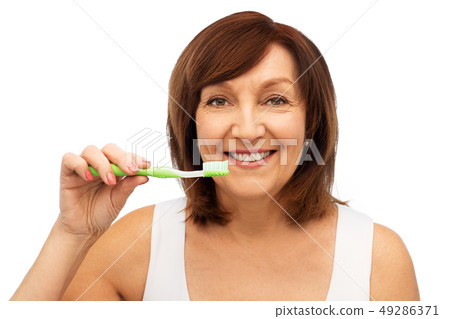 senior woman with toothbrush brushing her teeth senior woman with toothbrush brushing her teeth 49286371