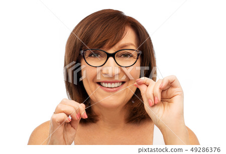 senior woman cleaning her teeth by dental floss senior woman cleaning her teeth by dental floss 49286376