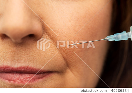close up of senior woman face and syringe close up of senior woman face and syringe 49286384