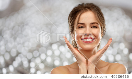 smiling young woman over grey background smiling young woman over grey background 49286416