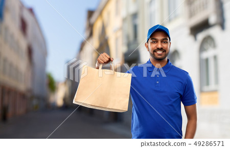 indian delivery man with food in paper bag in city indian delivery man with food in paper bag in city 49286571