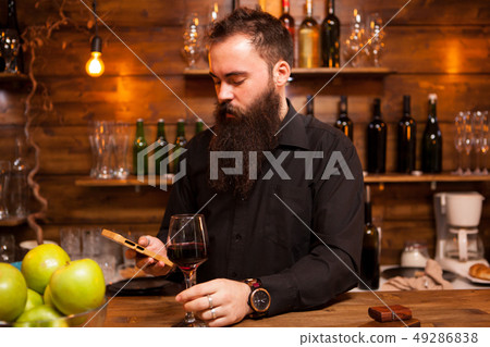 Bartender behind the counter enjoying a glass of wine Bartender behind the counter enjoying a glass of wine 49286838