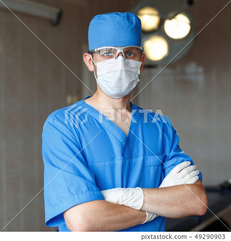 Surgeon in blue uniform, glasses and hat stands in Surgeon in blue uniform, glasses and hat stands in 49290903