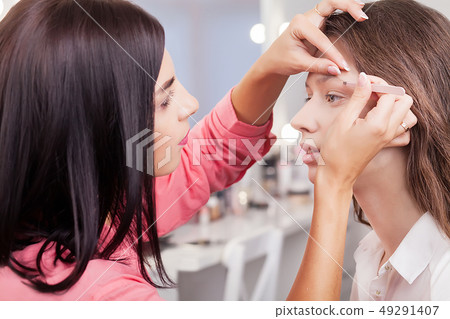 Backstage scene: visagiste at work doing glamour model makeup. 49291407