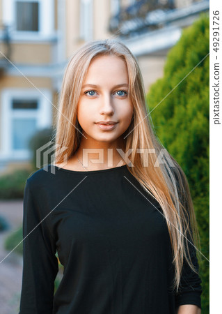 Beautiful blue-eyed girl near houses 49291726