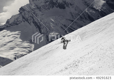 Snowboarder descends on off-piste ski slope Snowboarder descends on off-piste ski slope 49291823