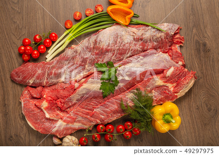 Raw beef on a wooden background with spices and Raw beef on a wooden background with spices and 49297975