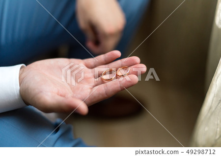 two wedding rings on the palm of the groom. two wedding rings on the palm of the groom. 49298712