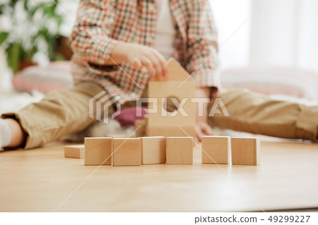 Little child sitting on the floor. Pretty boy palying with wooden cubes at home Little child sitting on the floor. Pretty boy palying with wooden cubes at home 49299227