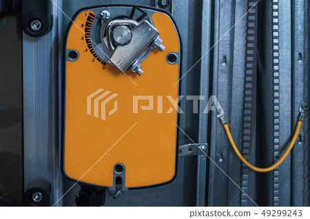 Orange damper actuator installed on the industrial ventilation unit body, front view Orange damper actuator installed on the industrial ventilation unit body, front view 49299243