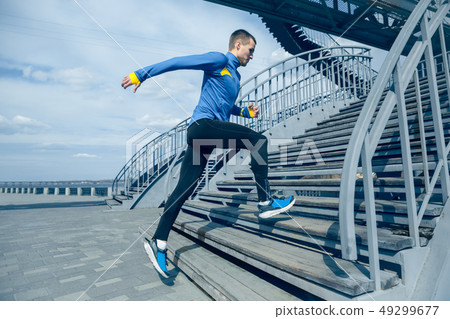Man running on city background at morning. 49299677