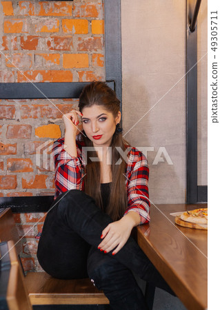 Beautiful and sexy girl sitting at a table with a Beautiful and sexy girl sitting at a table with a 49305711