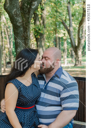 Two people in love sit on a bench in the park. Two people in love sit on a bench in the park. 49307818