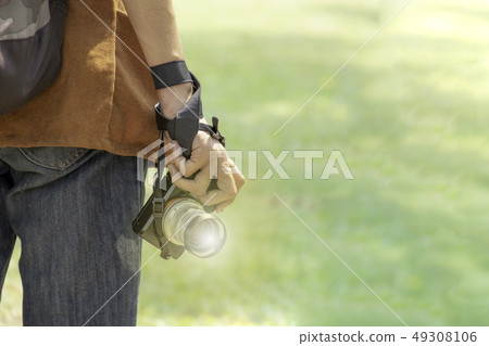 Young man with professional camera photographing Young man with professional camera photographing 49308106